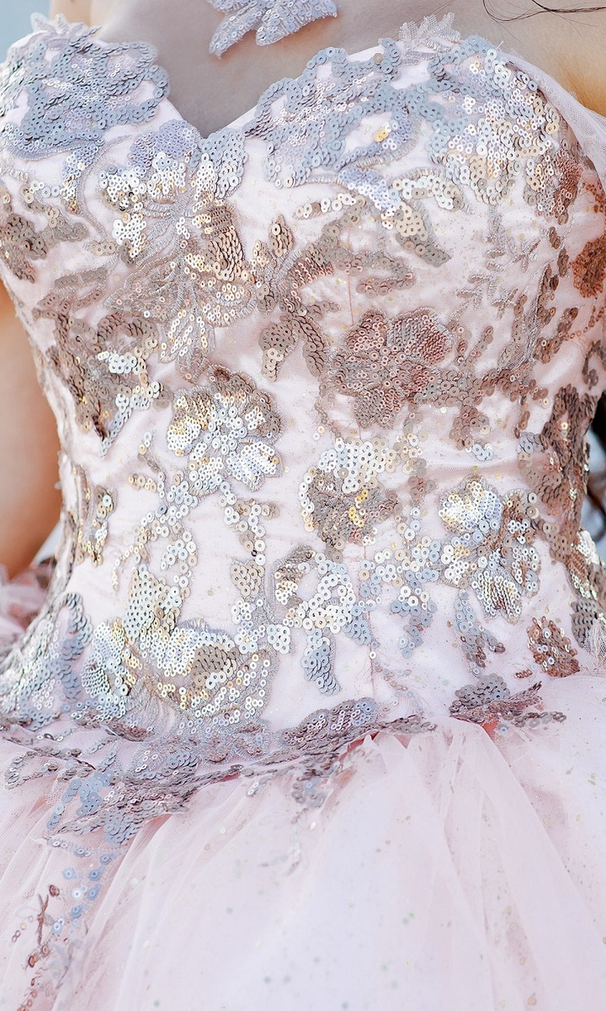 Close-up of Quinceanera Ball Gown 8064J: a pink off-the-shoulder dress with silver sequin floral embroidery and tulle fabric.